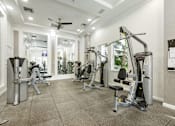 Thumbnail 10 of 40 - A spacious gym with a variety of equipment including treadmills, weights, and a rowing machine.