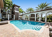 Thumbnail 6 of 40 - A pool surrounded by a white fence and palm trees.