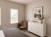 Thumbnail 32 of 37 - A bedroom with a bed, a chair, a dresser, and a painting on the wall.