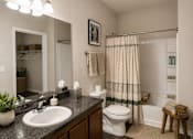 Thumbnail 34 of 37 - A bathroom with a white toilet, sink, and shower curtain.