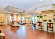 Thumbnail 9 of 33 - A living room with a kitchen area in the background.