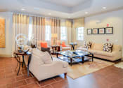 Thumbnail 7 of 33 - A living room with a white sofa, a coffee table, and a glass table with a vase on it.