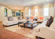 Thumbnail 10 of 33 - A living room with a white couch and a glass coffee table.