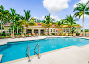 Thumbnail 15 of 33 - A pool surrounded by palm trees and lounge chairs.
