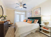 Thumbnail 20 of 30 - A bedroom with a bed, nightstand, and a ceiling fan.
