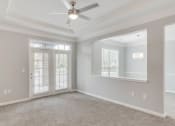 Thumbnail 16 of 17 - an empty living room with a ceiling fan and a mirror