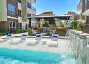 Thumbnail 9 of 17 - a pool with a waterfall and lounge chairs in front of a building