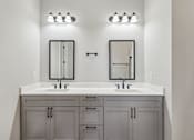 Thumbnail 23 of 38 - A bathroom with a double sink vanity and two mirrors.