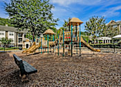 Thumbnail 23 of 25 - A playground with a slide and a wooden structure.