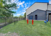 Thumbnail 21 of 26 - a large yard with two fire hydrants in the middle and a building in the background