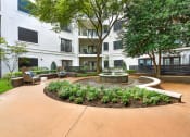 Thumbnail 18 of 37 - a courtyard with a fountain and trees in front of an apartment building