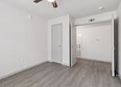 Thumbnail 20 of 38 - A room with a white door and a ceiling fan.