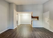 Thumbnail 18 of 29 - an empty living room with wood flooring and a white door