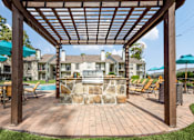 Thumbnail 23 of 29 - a backyard with a grill and a pool with umbrellas