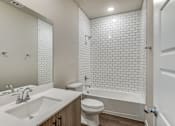 Thumbnail 7 of 20 - A white bathroom with a sink, toilet, and bathtub.