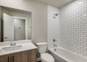 Thumbnail 10 of 20 - A white bathroom with a sink, toilet, and bathtub.