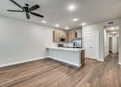 Thumbnail 1 of 20 - A spacious kitchen with a ceiling fan and wooden flooring.