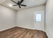 Thumbnail 5 of 20 - A room with a ceiling fan and a door.