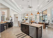 Thumbnail 26 of 26 - A modern kitchen with a large island and pendant lights.
