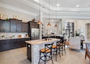 Thumbnail 25 of 26 - A modern kitchen with a bar area and a dining table.