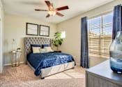Thumbnail 4 of 21 - A bedroom with a bed, a ceiling fan, and a nightstand.
