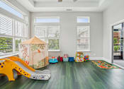 Thumbnail 24 of 26 - A child's play area with a slide, ball pit, and toys.