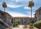 Thumbnail 11 of 20 - a row of apartments with stairs and palm trees