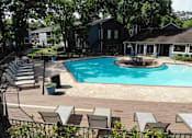 Thumbnail 23 of 29 - A pool surrounded by chairs and trees.