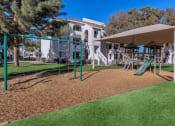 Thumbnail 20 of 23 - a playground with a slide and swings in front of a building
