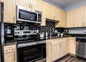 Thumbnail 5 of 28 - a kitchen with black appliances and wooden cabinets