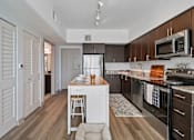 Thumbnail 17 of 34 - A kitchen with a white fridge and wooden cabinets.