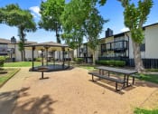 Thumbnail 27 of 34 - a picnic area with benches and trees in front of apartment buildings