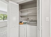 Thumbnail 11 of 16 - A white kitchen with a dishwasher and oven.