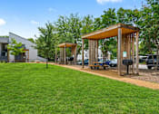 Thumbnail 14 of 19 - a group of wooden structures on a lawn with grass and trees
