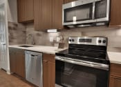 Thumbnail 3 of 17 - a kitchen with wooden cabinets and stainless steel appliances