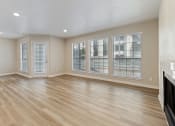 Thumbnail 10 of 28 - an empty living room with a fireplace and large windows