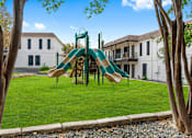 Thumbnail 4 of 22 - a playground with a slide in front of a building
