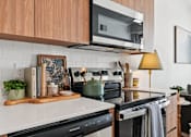 Thumbnail 3 of 26 - A kitchen with a white countertop and a black stove top oven.