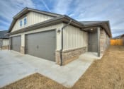 Thumbnail 1 of 19 - a home with two garage doors and a concrete driveway