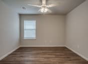 Thumbnail 16 of 19 - a bedroom with hardwood floors and a ceiling fan