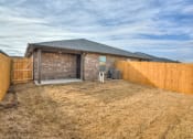 Thumbnail 19 of 19 - a backyard with a brick house and a wooden fence