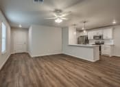 Thumbnail 5 of 19 - an empty living room with a kitchen in the background