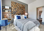 Thumbnail 2 of 36 - A bedroom with a large bed and a blue chair.