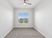 Thumbnail 17 of 42 - A room with a ceiling fan and a window with blinds.