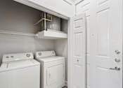 Thumbnail 20 of 42 - A white laundry room with a washer and dryer.