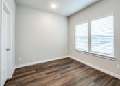 Thumbnail 15 of 15 - A room with wooden flooring and a window with blinds.