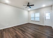 Thumbnail 11 of 15 - A room with a ceiling fan and wooden flooring.