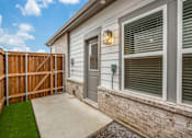 Thumbnail 5 of 15 - A house with a brown fence and a grey door.