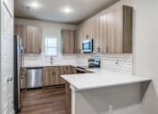 Thumbnail 7 of 15 - A kitchen with wooden cabinets and a white countertop.
