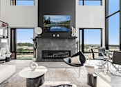 Thumbnail 14 of 35 - A modern living room with a fireplace and a flat screen TV.